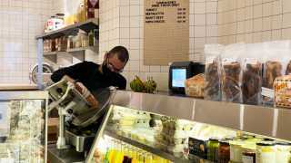 A staff member slices meat inside Russell's Butcher & Deli