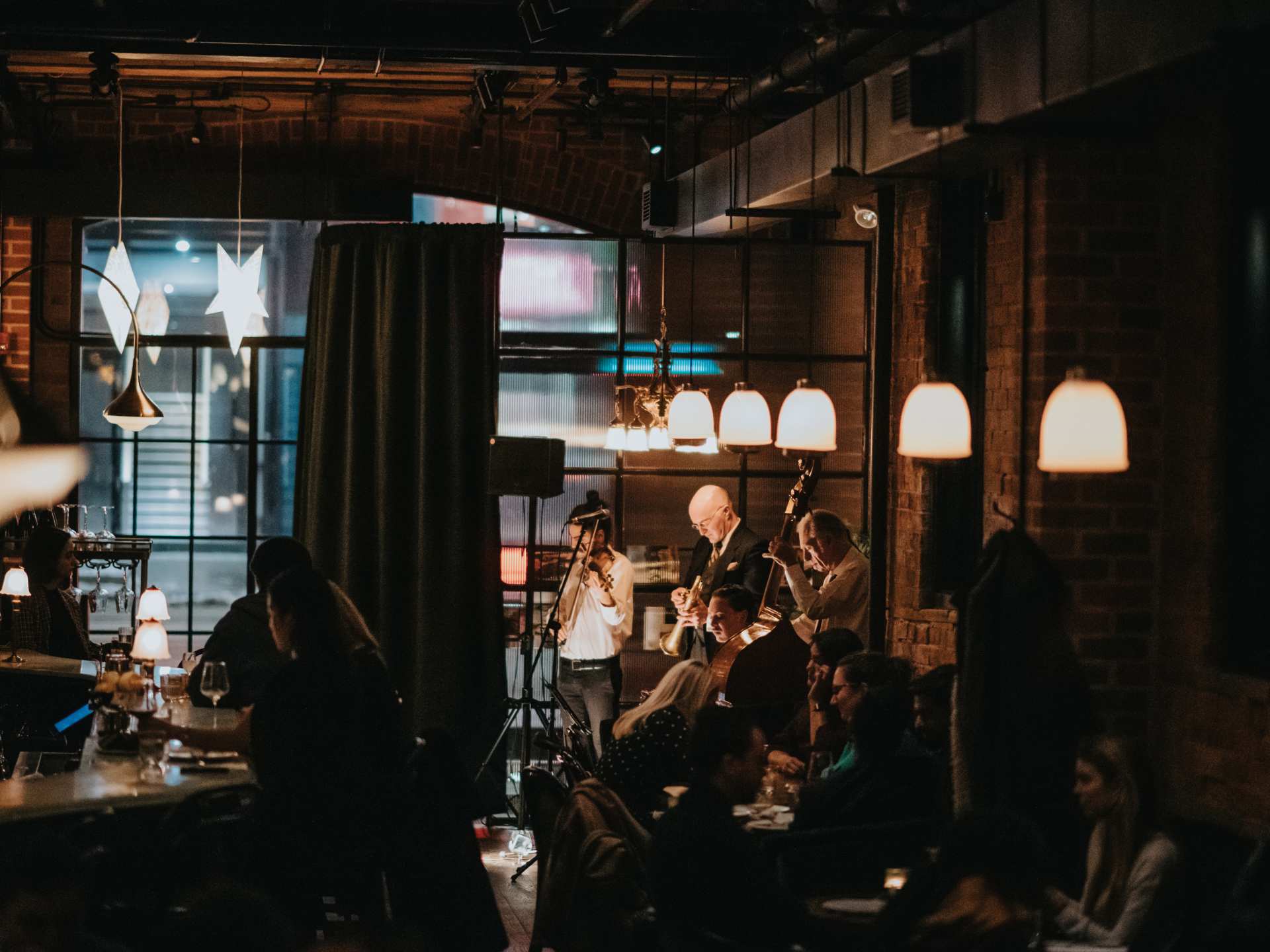 Restaurants and bars with live music in Toronto | Guests at the bar watch a small band playing inside Lapinou