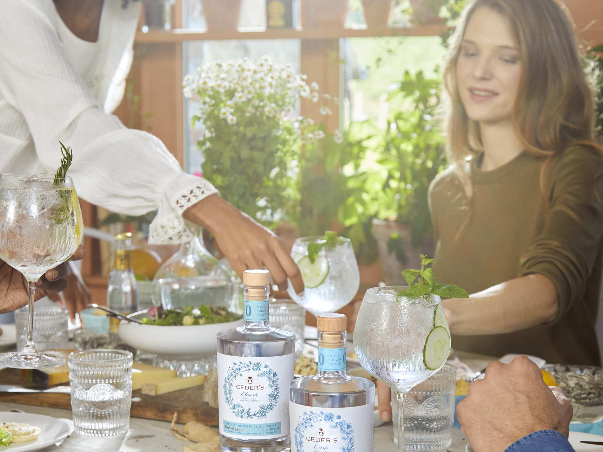 Two people with Ceder's at a dinner table and clear cocktails