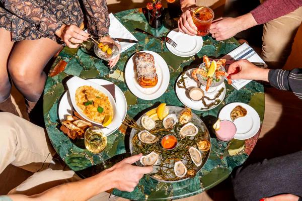 People grabbing at a spread of dishes at The Joneses restaurant in Toronto