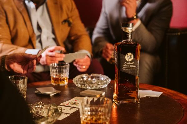 Rabbit Hole Kentucky bourbon on a table with a card game