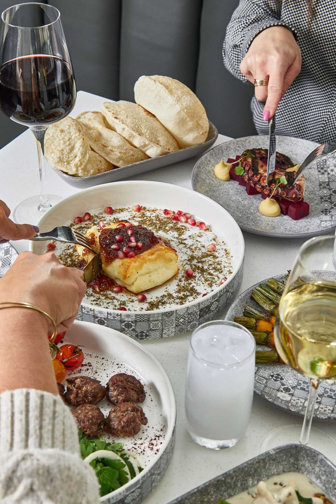 Two people dig into dishes at Miss Aida in Toronto