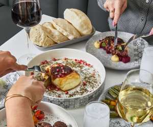 Two people dig into dishes at Miss Aida in Toronto