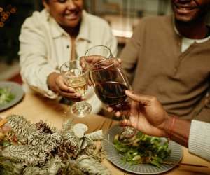 People toast with wine at a festive dinner table