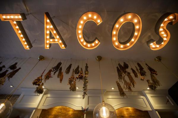 The neon TACOS sign inside La Bartola in Toronto