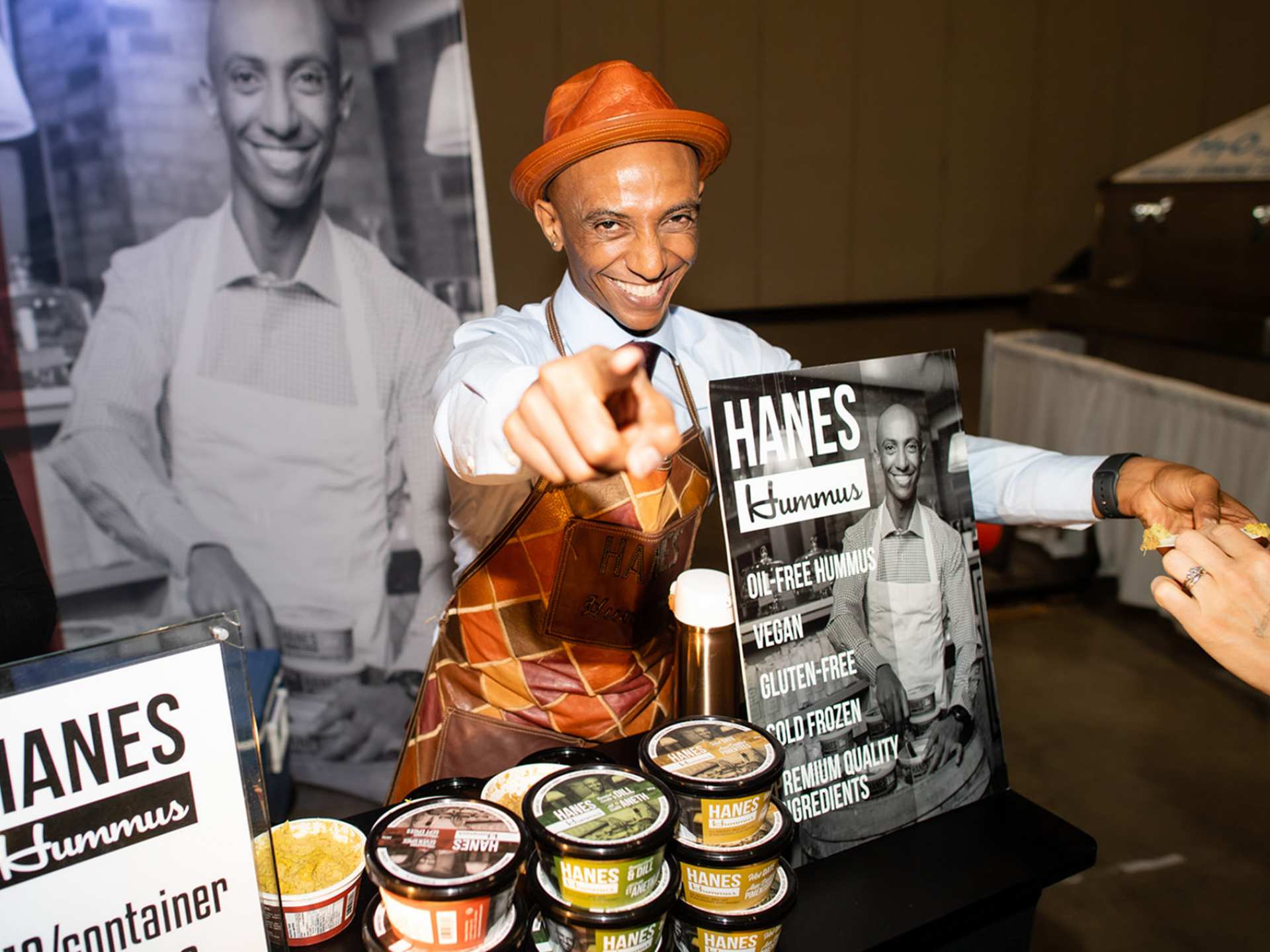 A vendor at Planted Expo Toronto smiling and pointing at the camera